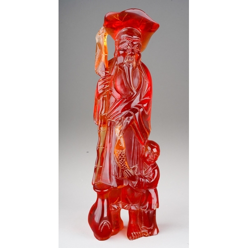 69 - Chinese carved red composition amber style figure of a fisherman and a child, 35cm tall