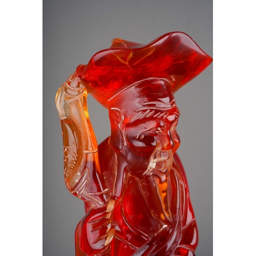 69 - Chinese carved red composition amber style figure of a fisherman and a child, 35cm tall