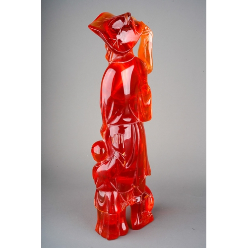 69 - Chinese carved red composition amber style figure of a fisherman and a child, 35cm tall