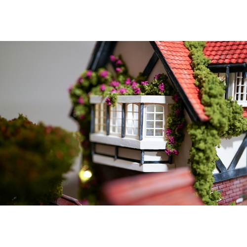 410 - A scale model diorama of a Tudor cottage with garden and streams in the style of Lilliput Lane, fitt... 