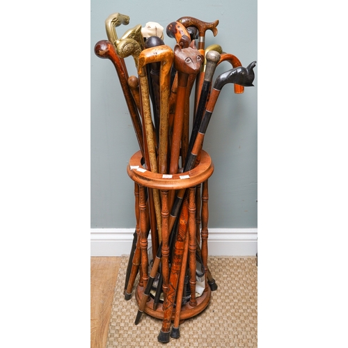 414 - Collection of Walking sticks in a stand to include a silver topped ones, brass, horn  and carved woo... 