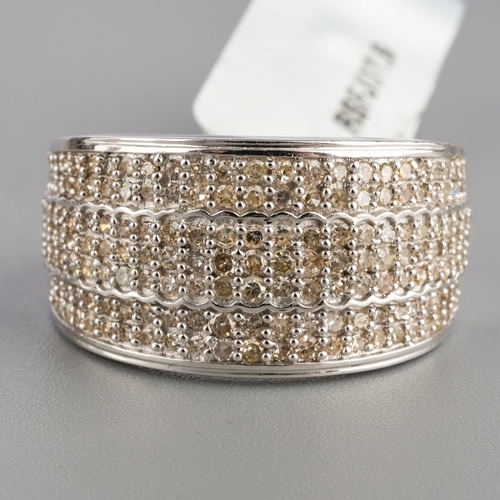 541 - A hallmarked 9ct white gold and diamond pave ring, set with seven rows of pave diamonds to tapered s... 