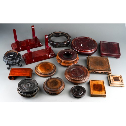 210 - A collection of seventeen late 19th / 20th century Oriental wooden display stands, various shapes an... 