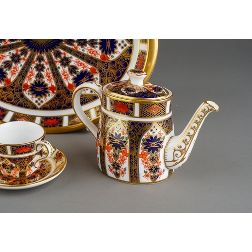 35 - A Royal Crown Derby Imari 1128 pattern miniature five piece tea set and oval tray, the tea set compr... 