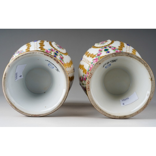 64 - A pair of early 20th Century Vienna porcelain vases, each profusely decorated with gilt and painted ... 