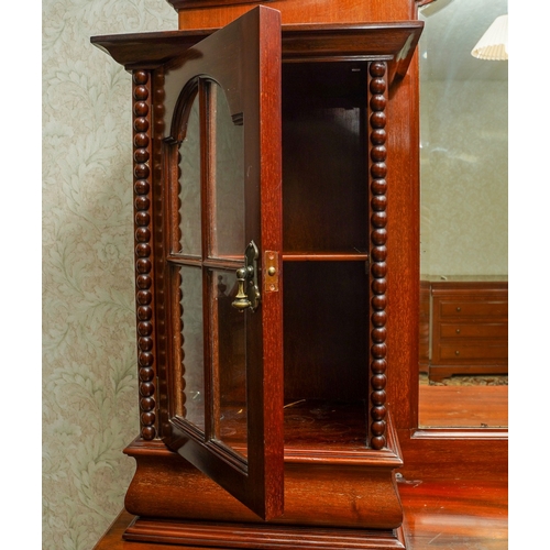 388 - A 1920's mirror back sideboard, with glazed single door cabinets flanking the mirrored back, the bas... 