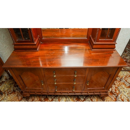 388 - A 1920's mirror back sideboard, with glazed single door cabinets flanking the mirrored back, the bas... 