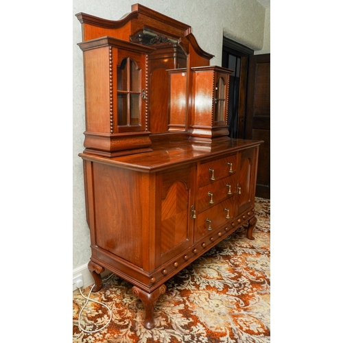 388 - A 1920's mirror back sideboard, with glazed single door cabinets flanking the mirrored back, the bas... 