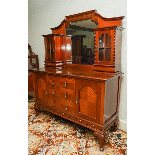 388 - A 1920's mirror back sideboard, with glazed single door cabinets flanking the mirrored back, the bas... 