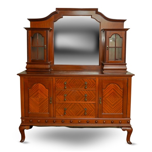 388 - A 1920's mirror back sideboard, with glazed single door cabinets flanking the mirrored back, the bas... 