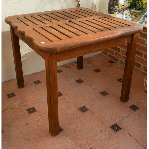 390 - A modern stained teak two seat garden bench with angled two tier table to centre, overall width 154c... 