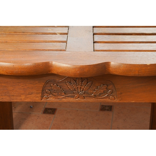 390 - A modern stained teak two seat garden bench with angled two tier table to centre, overall width 154c... 