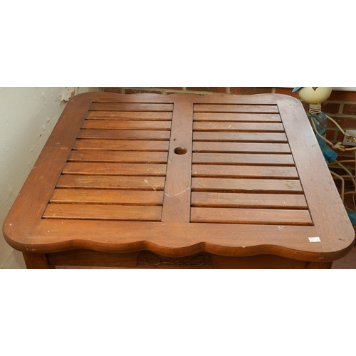 390 - A modern stained teak two seat garden bench with angled two tier table to centre, overall width 154c... 