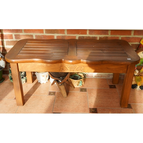 390 - A modern stained teak two seat garden bench with angled two tier table to centre, overall width 154c... 