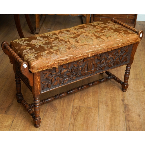 392 - A Jacobean Revival carved oak rectangular bench / piano stool, bobbin turned handles above carved ap... 