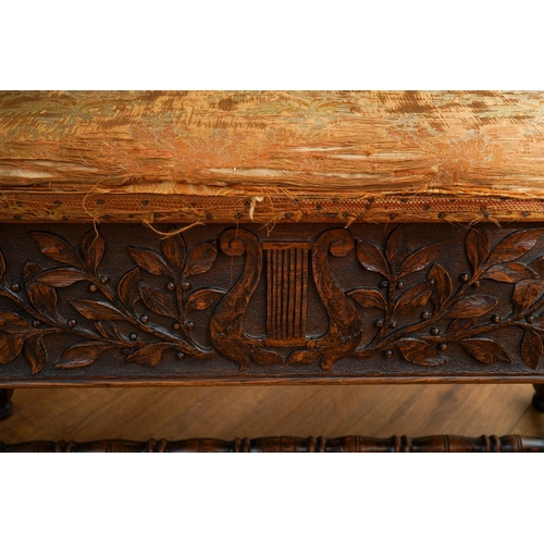 392 - A Jacobean Revival carved oak rectangular bench / piano stool, bobbin turned handles above carved ap... 