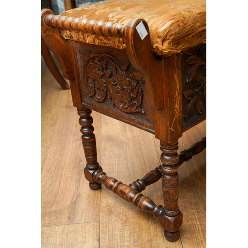 392 - A Jacobean Revival carved oak rectangular bench / piano stool, bobbin turned handles above carved ap... 