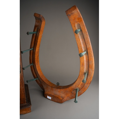 394 - An early 20th Century carved mahogany novelty coat wall rack in the form of a horse shoe with eight ... 