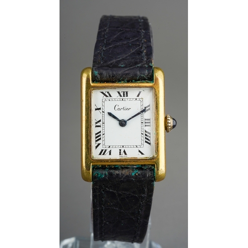 A Cartier Tank Electroplated wristwatch. The white dial with black hourly applied Roman numerals, blue steel hands, dial signed "Cartier Swiss" case back signed Cartier and stamped 18k gold electroplated Swiss, together with personal engraving, watch on an associated unsigned leather strap with unmarked Tang style buckle, watch with accompanying Cartier case, gross weight 18.36 grams, the working order of the watch can not be guaranteed