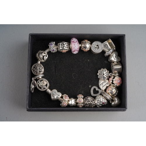 676 - Pandora style charm bracelet with approx. 21 charms on it
