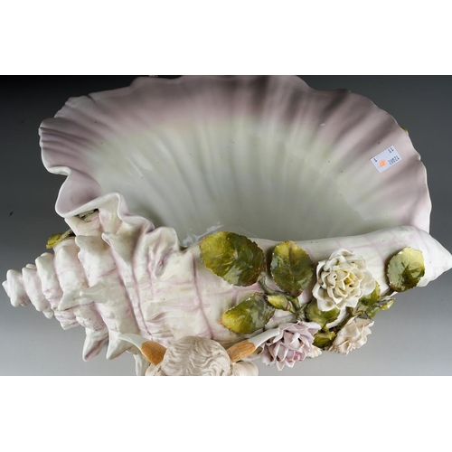 10 - A Sitzendorf large figural table centrepiece modelled a conch shell applied with flowers and foliage... 