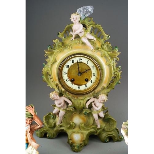 11 - A Continental porcelain Rococo style mantle clock., the apple green and gilt scrolling case applied ... 