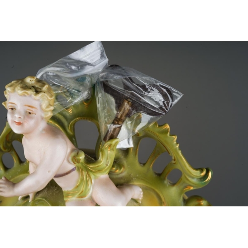 11 - A Continental porcelain Rococo style mantle clock., the apple green and gilt scrolling case applied ... 