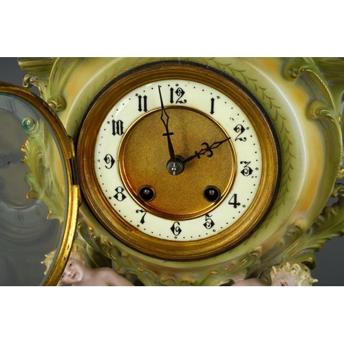 11 - A Continental porcelain Rococo style mantle clock., the apple green and gilt scrolling case applied ... 