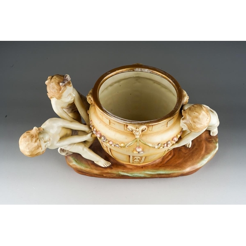 12 - An early 20th Century Amphora porcelain blush ivory large figural jardiniere modelled as three child... 