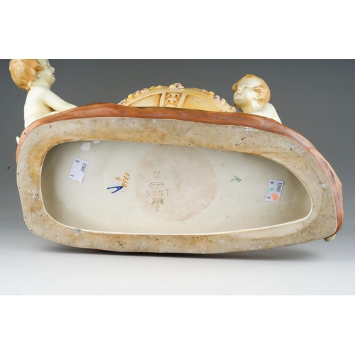 12 - An early 20th Century Amphora porcelain blush ivory large figural jardiniere modelled as three child... 