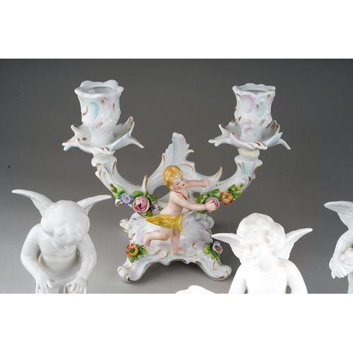 15 - A pair of Dresden Sitzendorf figural candelabra., the urn shaped sconces on scroll branches applied ... 