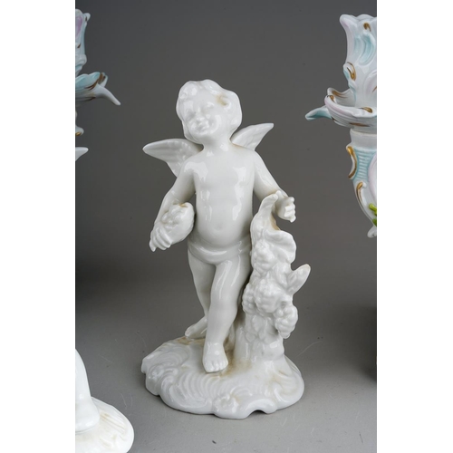 15 - A pair of Dresden Sitzendorf figural candelabra., the urn shaped sconces on scroll branches applied ... 