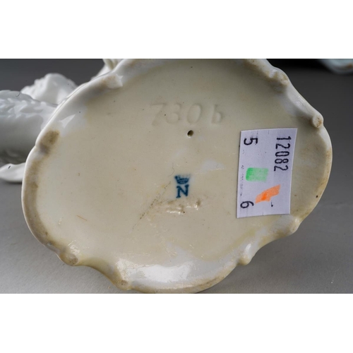 15 - A pair of Dresden Sitzendorf figural candelabra., the urn shaped sconces on scroll branches applied ... 