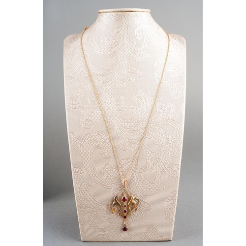 29 - An early 20th century 9ct gold gem set pendant and chain. The scroll design pendant set with garnets... 
