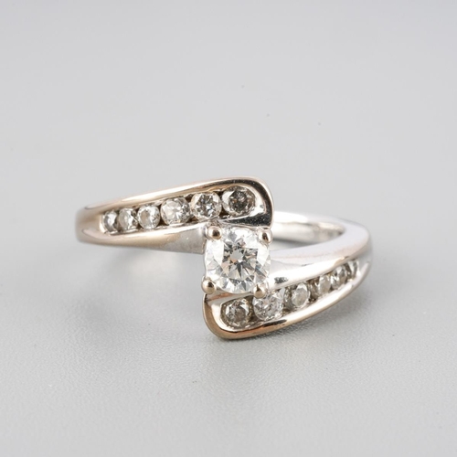 38 - An 18ct white gold diamond cross over ring. Set with round brilliant cut diamonds. Approx ring size ... 