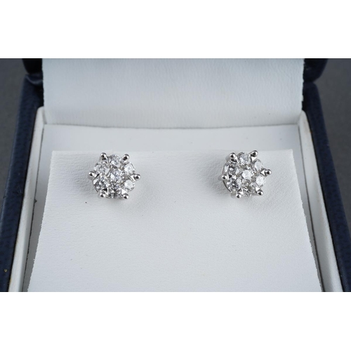 39 - A pair of 18ct white gold diamond cluster earrings. Each ear stud set throughout with round brillian... 