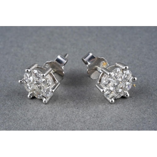 39 - A pair of 18ct white gold diamond cluster earrings. Each ear stud set throughout with round brillian... 