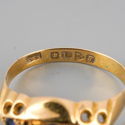 50 - An Edwardian sapphire and diamond ring. Set with a principal circular shape sapphire, flanked to eac... 