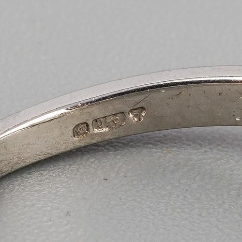 52 - A platinum diamond dress ring. Set with a principal emerald-cut diamond, rubover set, to the baguett... 