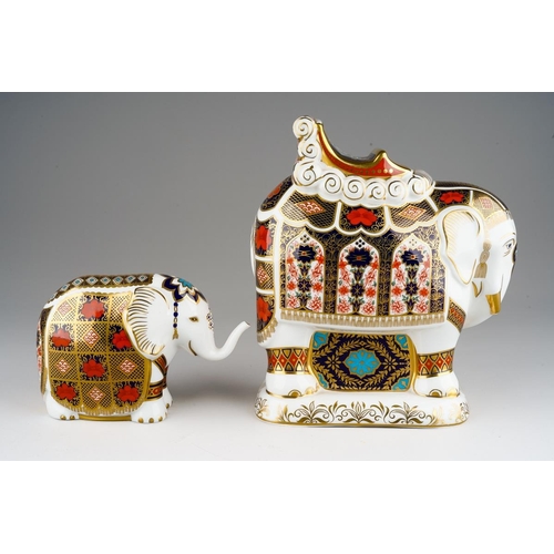 A Royal Crown Derby large Imari elephant paperweight modelled with a Houdah, gold stopper, red backstamp together with a smaller Indian elephant Imari paperweight, gold stopper, red backstamp [2]