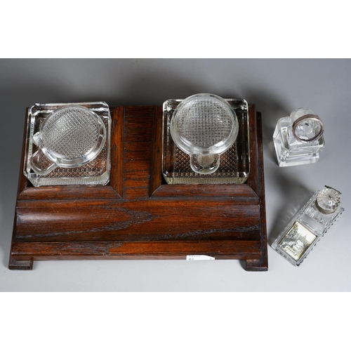385 - A 1930s stained oak inkstand with a pair of moulded glass bottles together with two early 20th Centu... 