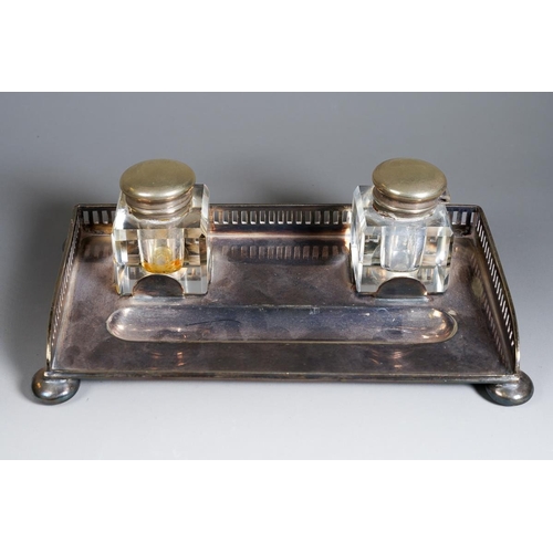 386 - An early 20th Century silver plate inkwell with gallery rail on bun feet with a pair of glass inkbot... 