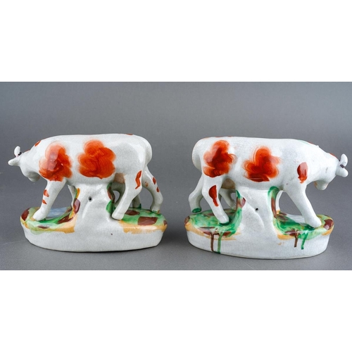 252 - A pair of Staffordshire type models, each with a red and white Cows with her calf, unmarked [2]