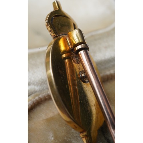 18 - A King George V yellow metal and Enamel Stick Pin. The head tests as 18ct, the pin tests as 9ct. 
Ho... 