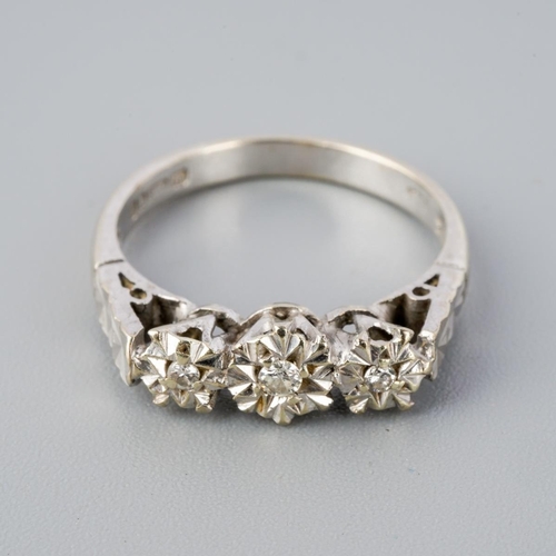 295 - A 9ct gold diamond three stone ring. Set with round brilliant cut diamonds within illusion style set... 
