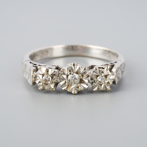 295 - A 9ct gold diamond three stone ring. Set with round brilliant cut diamonds within illusion style set... 