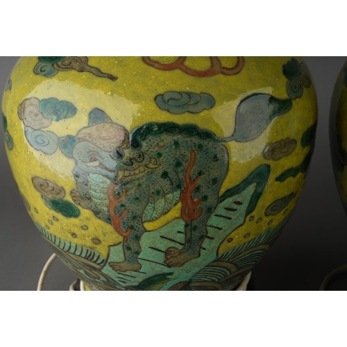 123 - A pair of Chinese baluster vases, each lime green ground decorated with Mythical beasts standing on ... 