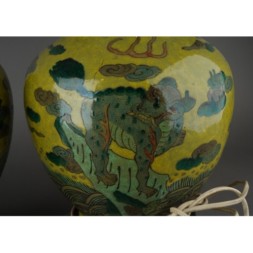 123 - A pair of Chinese baluster vases, each lime green ground decorated with Mythical beasts standing on ... 