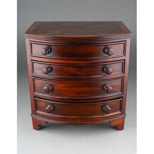 206 - A reproduction miniature mahogany bow front chest of four graduated drawers in the early 19th centur... 