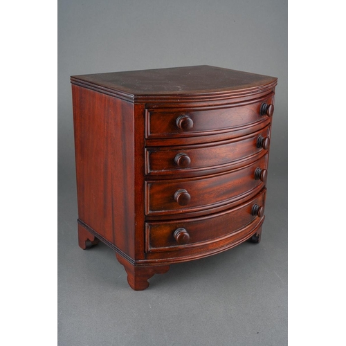 206 - A reproduction miniature mahogany bow front chest of four graduated drawers in the early 19th centur... 
